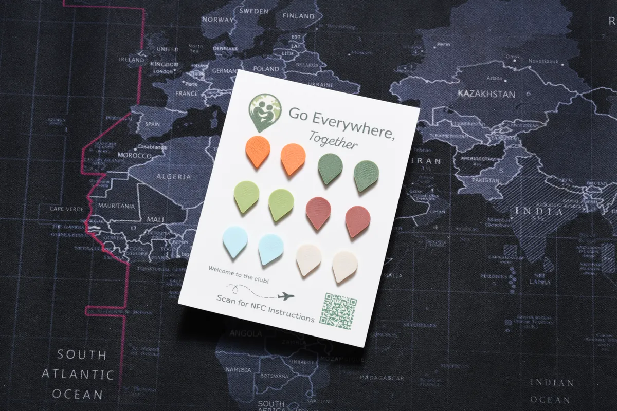 A card of Touch-to-Travel pins in orange, green, blue and white